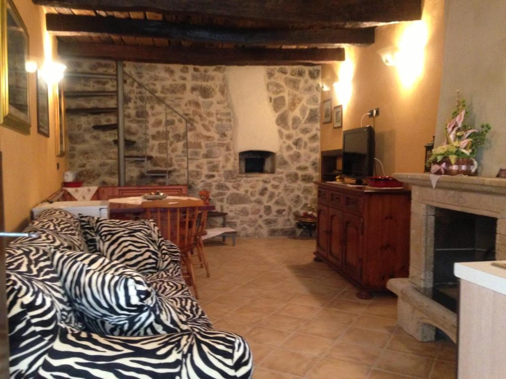 een woonkamer met een bank en een open haard bij Il borgo 28 in Scapoli