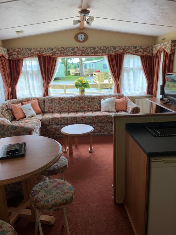 ein Wohnzimmer mit einem Sofa und einem Tisch in der Unterkunft 62 Glenfinart Caravan Park in Dunoon