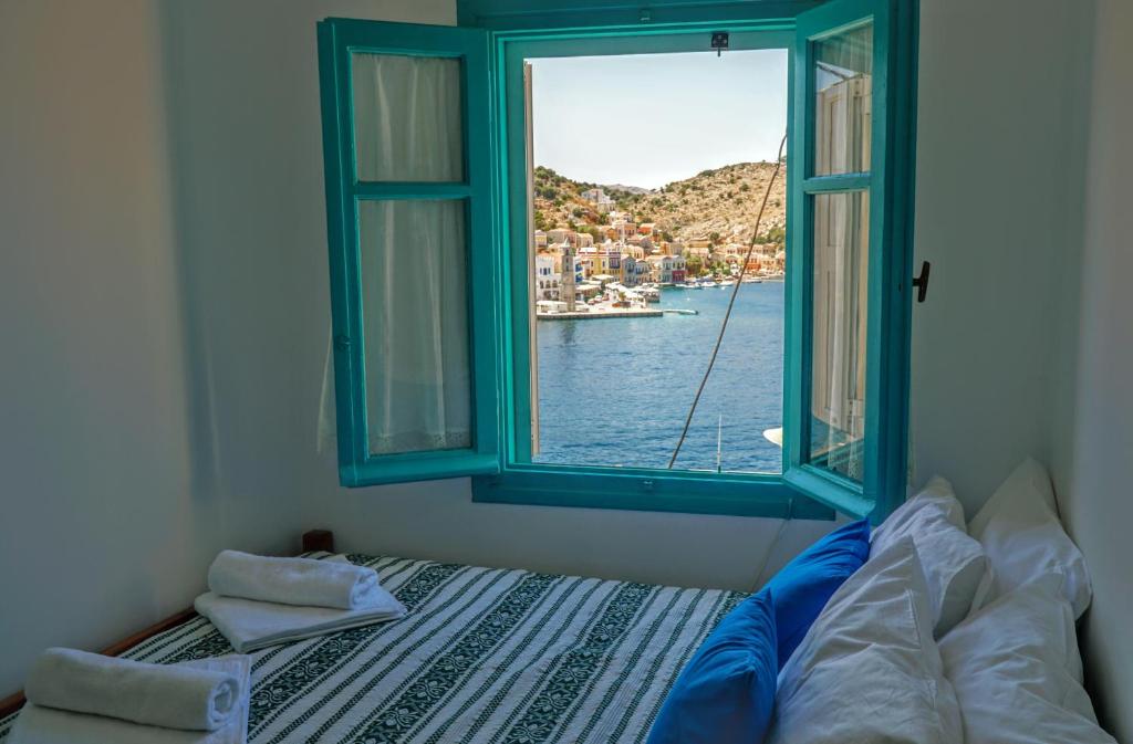 a bedroom with a window with a view of the water at Villa Pitini in Symi