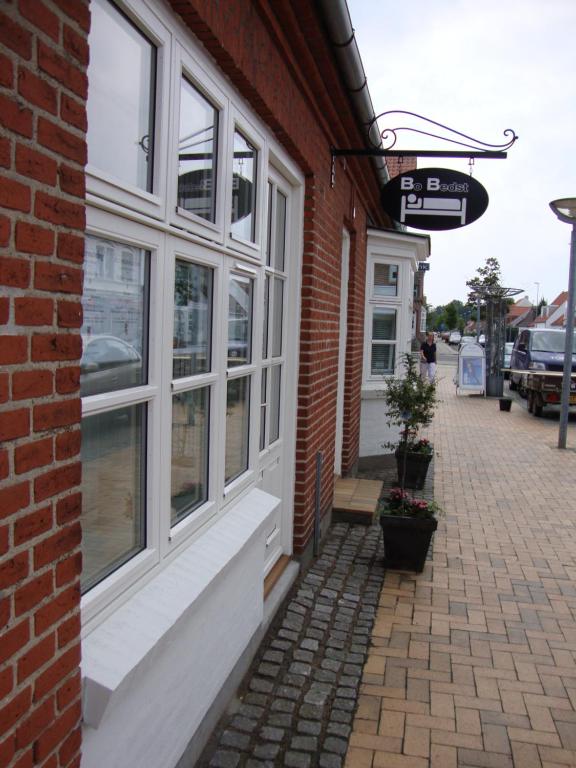 un edificio de ladrillo con ventanas en una calle en Bo Bedst Juelsminde, en Juelsminde