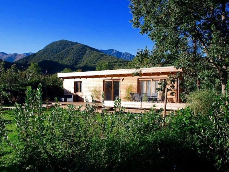 a small house with mountains in the background at Ecoartlodge in Finestret