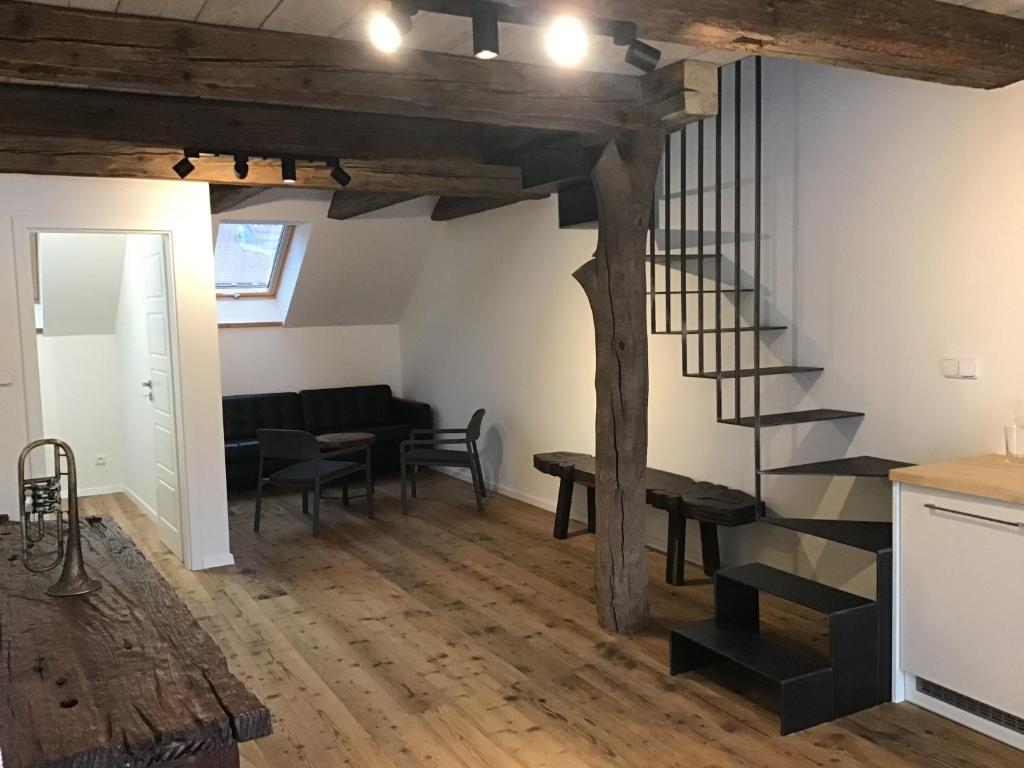 a living room with a spiral staircase and a table at Apartmány Sebastian in Mikulov