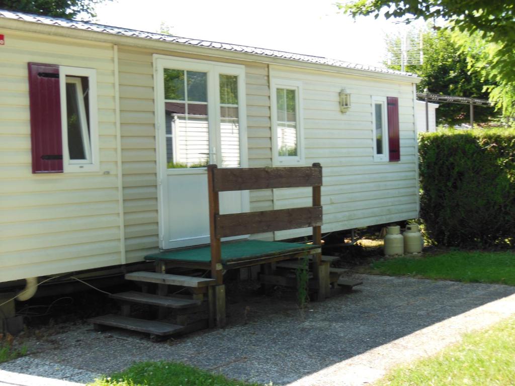 un banc assis à l'extérieur d'une petite maison dans l'établissement CAMPING LE GRAND VERNEY, à Novalaise