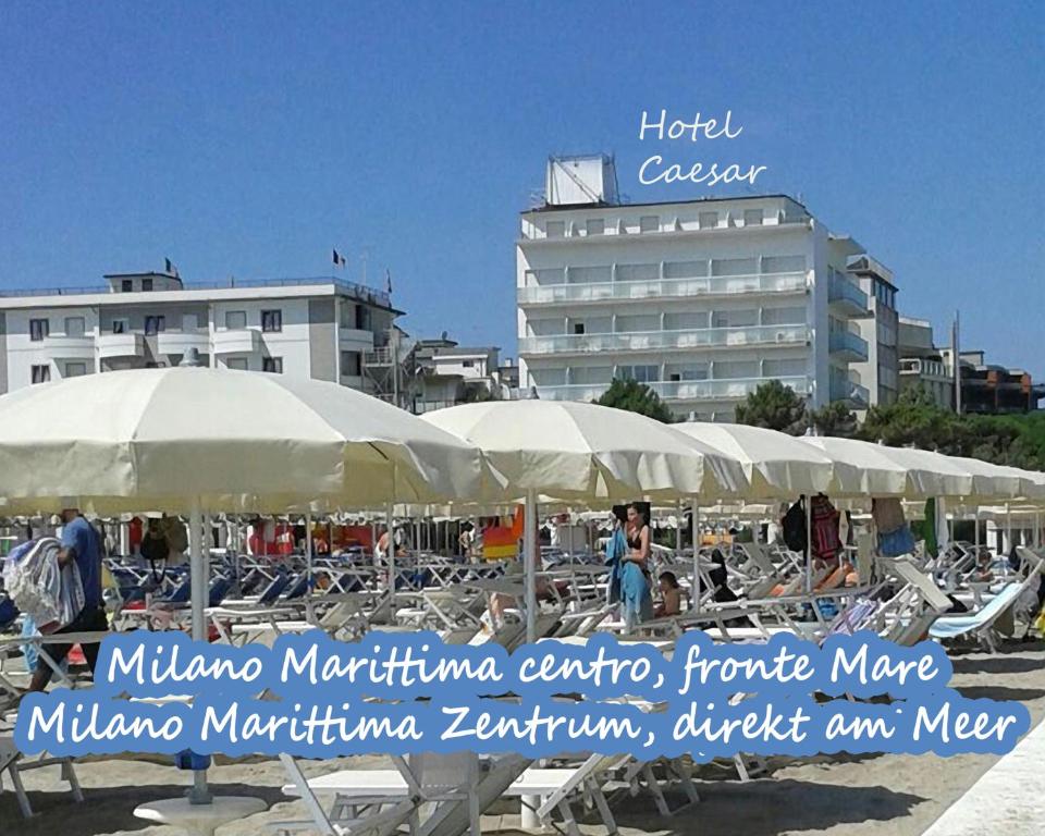 - un groupe de parasols et de chaises sur une plage dans l'établissement Hotel Caesar Bed and Breakfast, à Milano Marittima