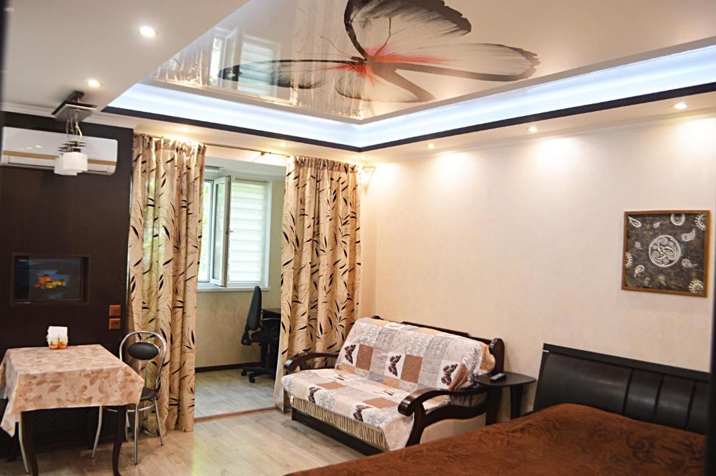 Habitación con cama, mesa y techo. en 2 room Lux Apartment on Kulika Street, en Kherson