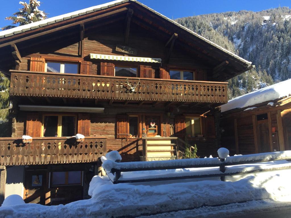 The cosy Isba - Chambre d hôtes - Val de Bagnes - Verbier في Versegeres : كابينة خشب مع شرفة في الثلج