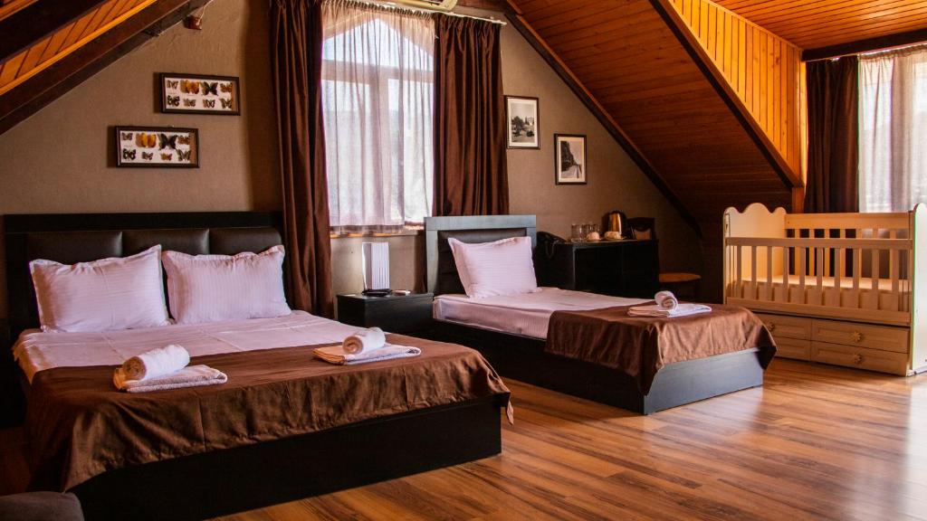 1 dormitorio con 2 camas y 1 cuna en Hotel New Metekhi, en Tiflis