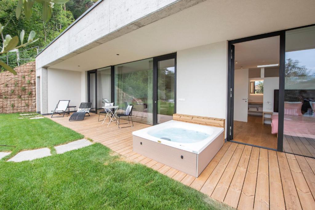 a house with a hot tub on a deck at La Vinea in Caldaro