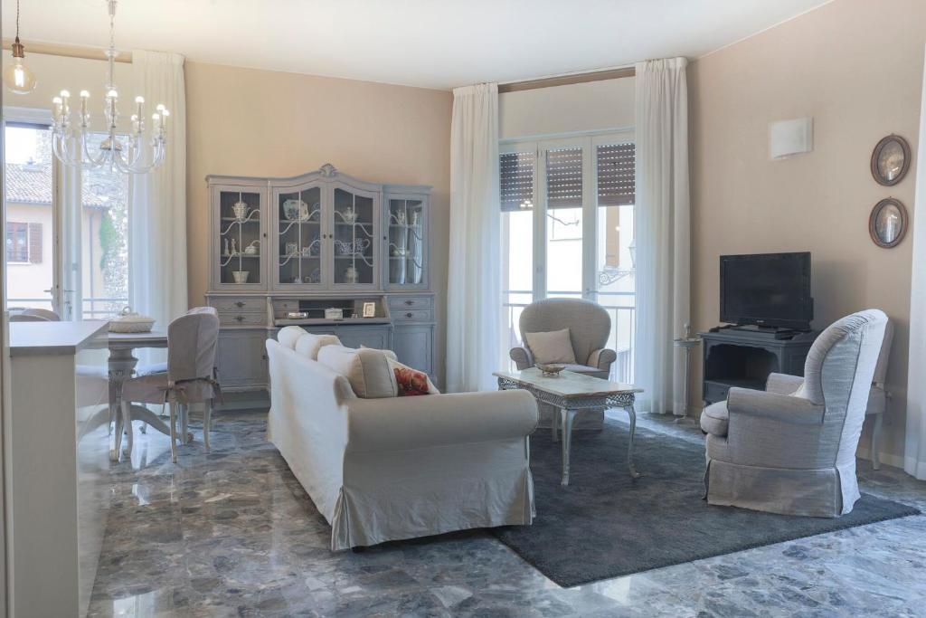 a living room with a white couch and chairs at Casa dello Speziale in bedizzol