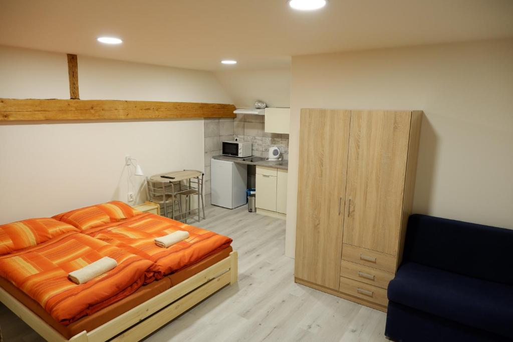 ホルニー・プラナーにあるApartments Habertのベッドルーム(オレンジ色のベッド1台付)、キッチン
