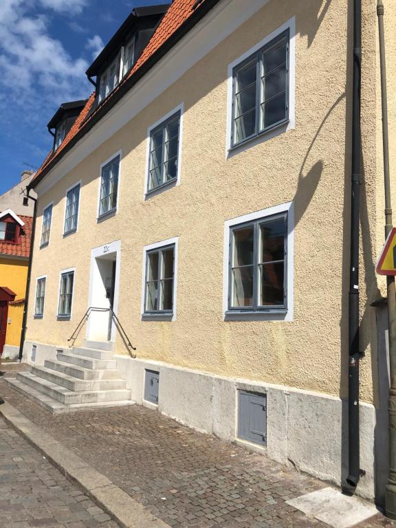 a building with white windows and stairs on a street at Apartments Strandgatan Visby in Visby