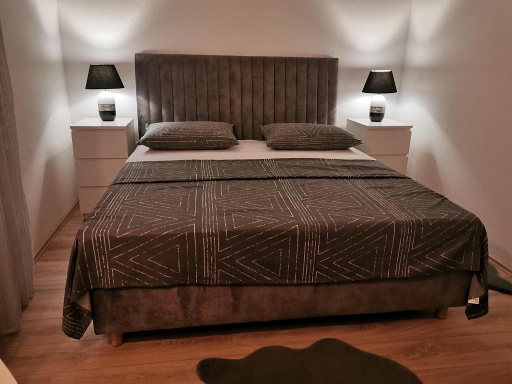 een slaapkamer met een groot bed met 2 lampen bij Five star appartman Senj in Senj