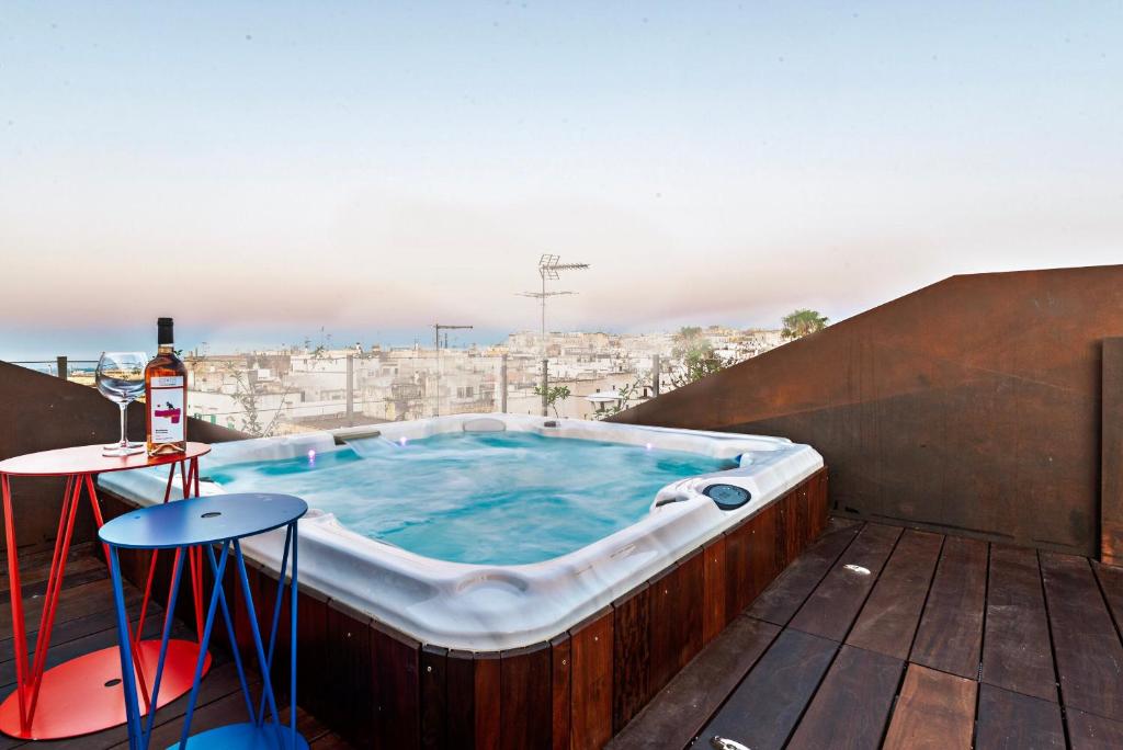 bañera de hidromasaje en el balcón de un edificio en Palazzo Biancofiore, suites - rooftop - spa, en Ostuni
