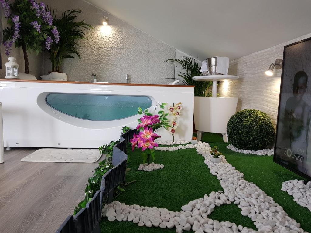 een kamer met een zwembad en een bloementuin bij Bed&breakfast Albysuite in Termoli