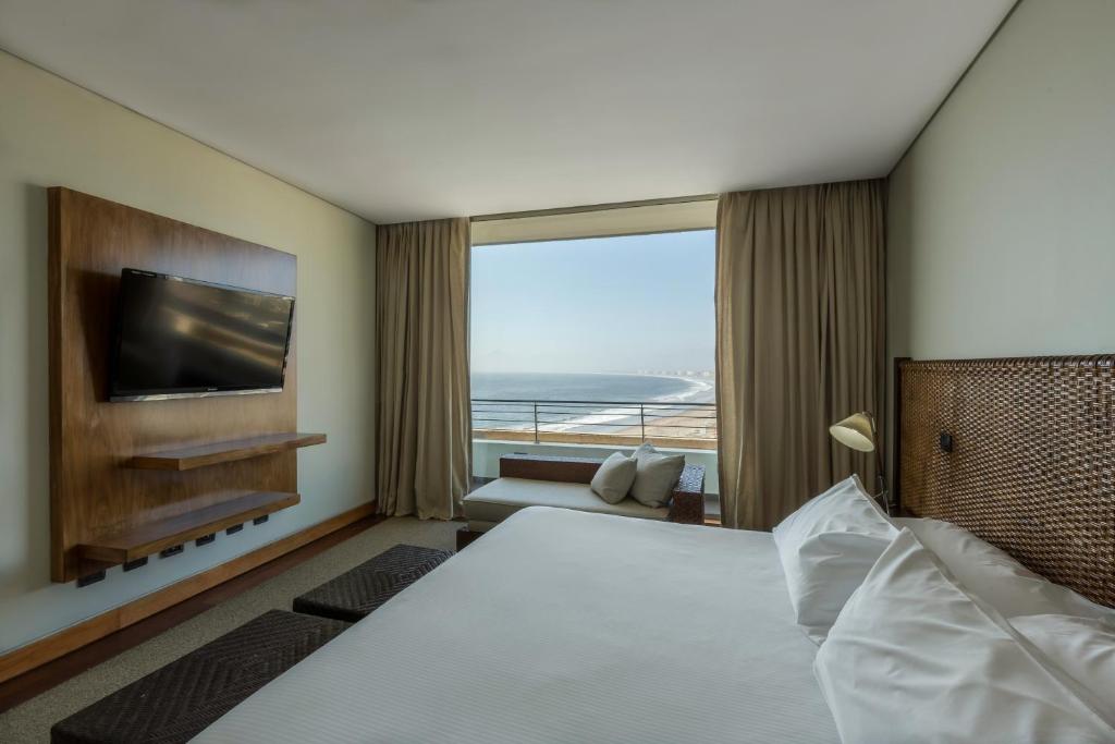 a hotel room with a bed and a television at Enjoy Coquimbo in Coquimbo