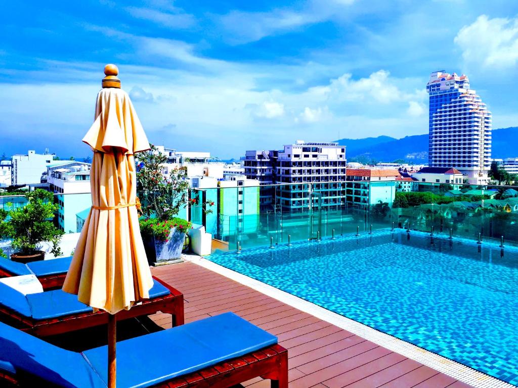 a pool and an umbrella on top of a building at Mirage Express Patong Phuket Hotel in Patong Beach