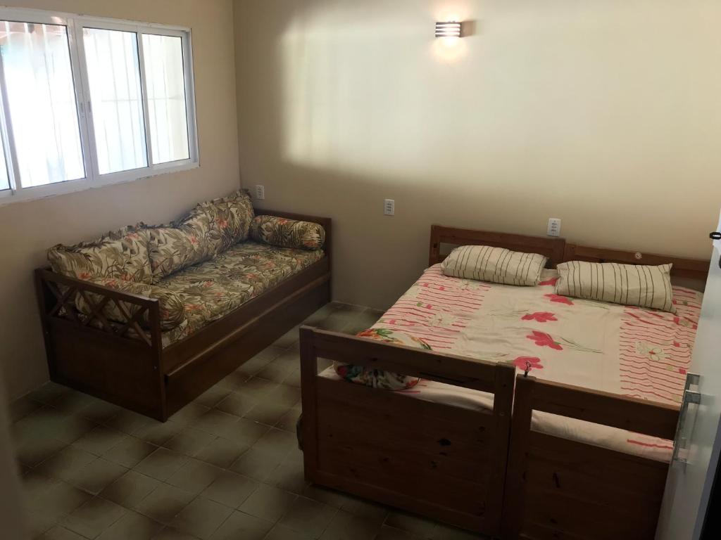 sala de estar con cama y sofá en Casa Ubatuba, en Ubatuba