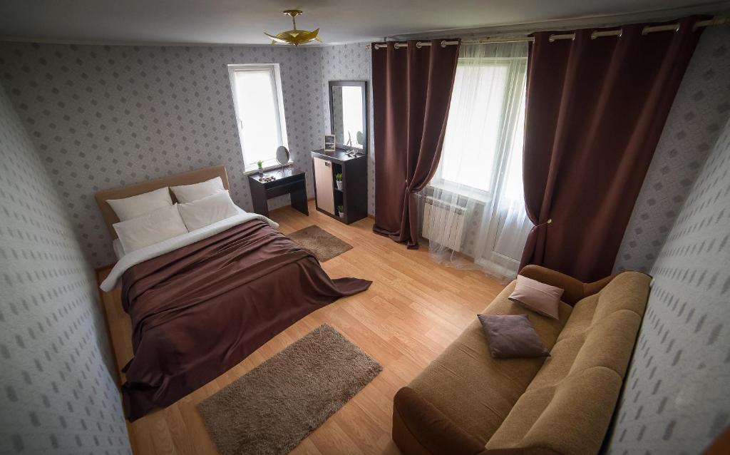 a bedroom with a bed and a couch at PaulMarie Apartments on Zaslonova 74 in Soligorsk