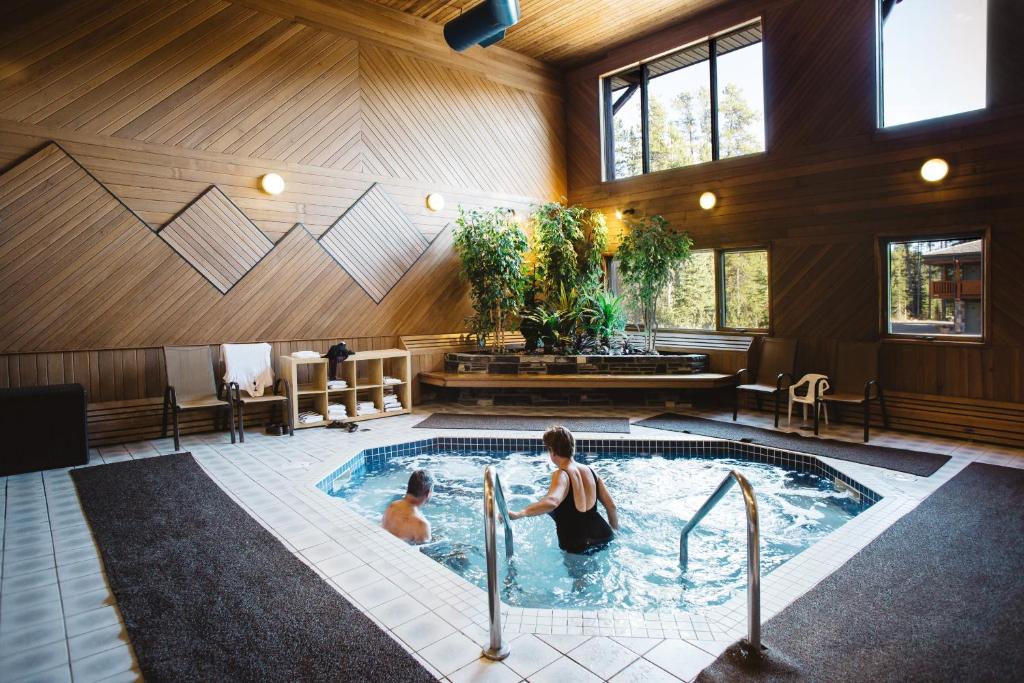 two people in a swimming pool in a house at Mountaineer Lodge in Lake Louise