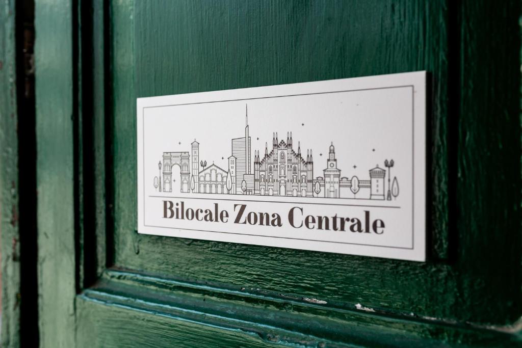 米蘭的住宿－Bilocale Zona Centrale，门上带有城市照片的标志