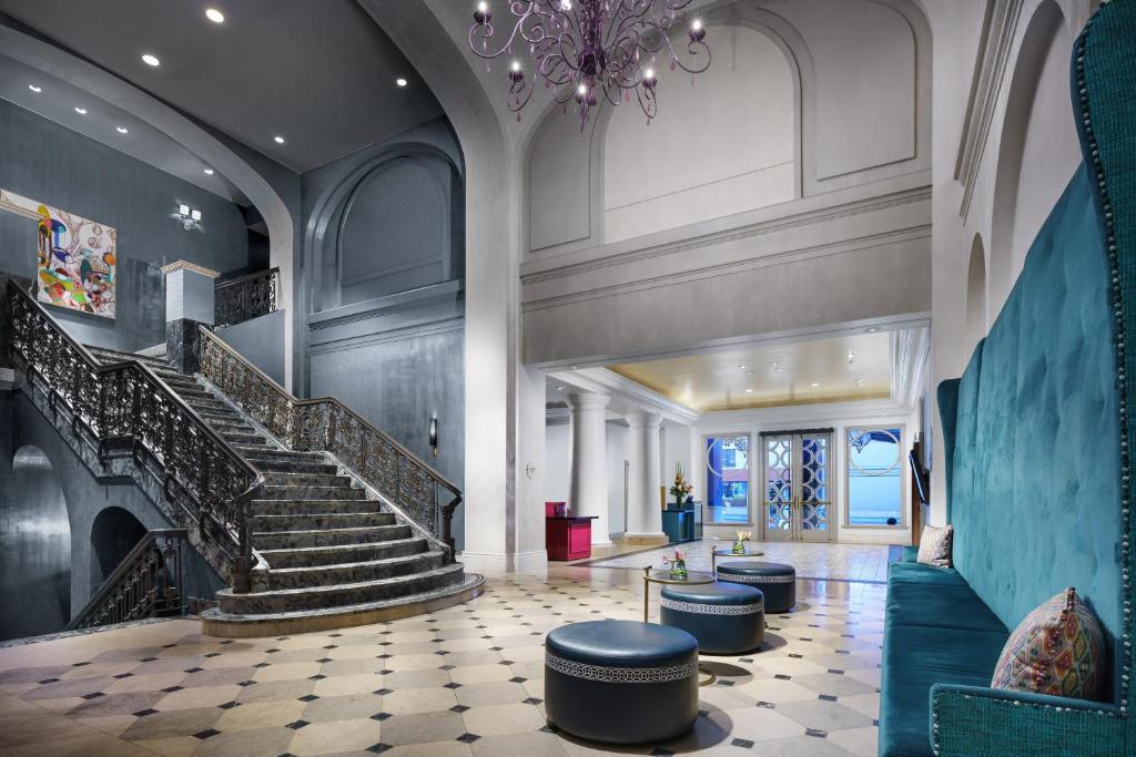 eine Lobby mit Treppen, Stühlen und einem Kronleuchter in der Unterkunft The Marker Union Square San Francisco in San Francisco