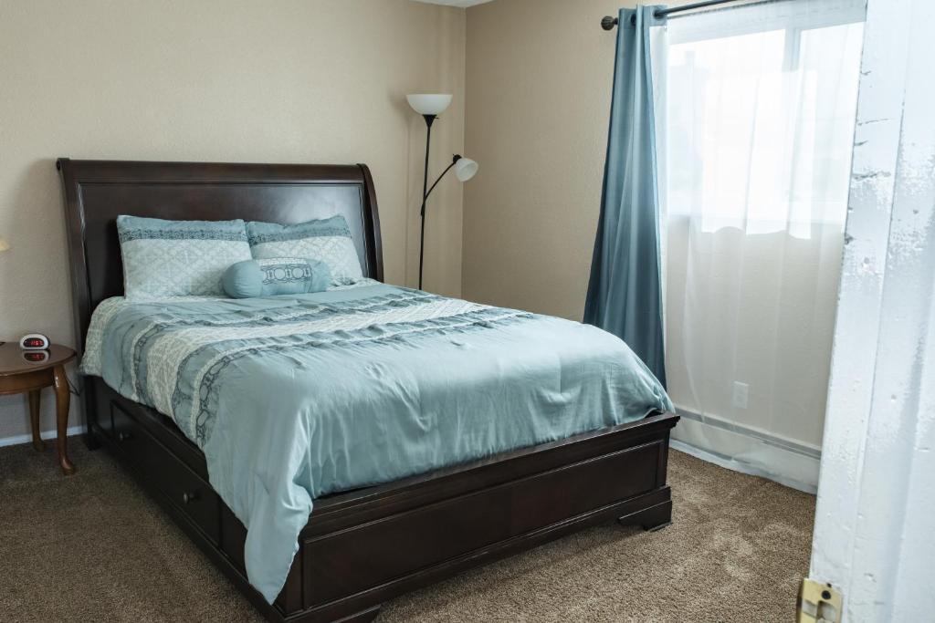 a bedroom with a bed with blue sheets and a window at Mountain Song in Colorado Springs