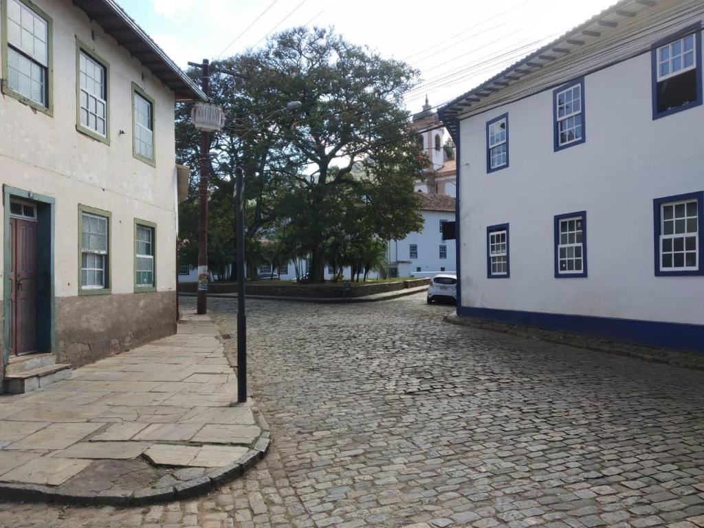 uma rua de calçada ao lado de dois edifícios brancos em Casa próxima ao centro de convenções da UFOP em Ouro Preto