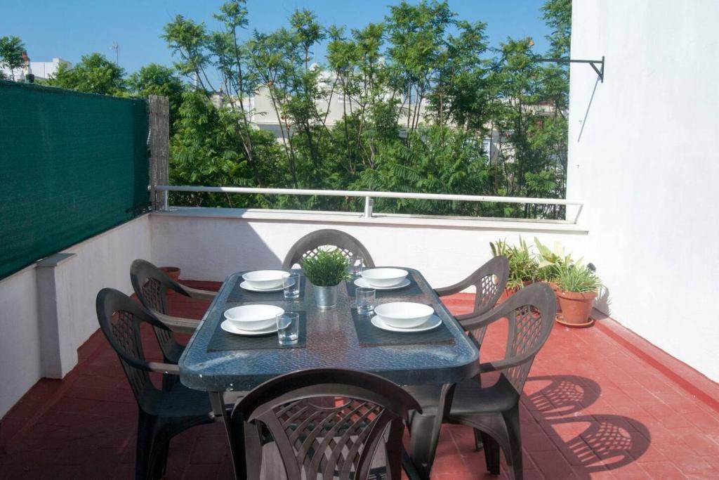 een blauwe tafel en stoelen op een balkon met uitzicht bij El mirador del Mentidero in Cádiz