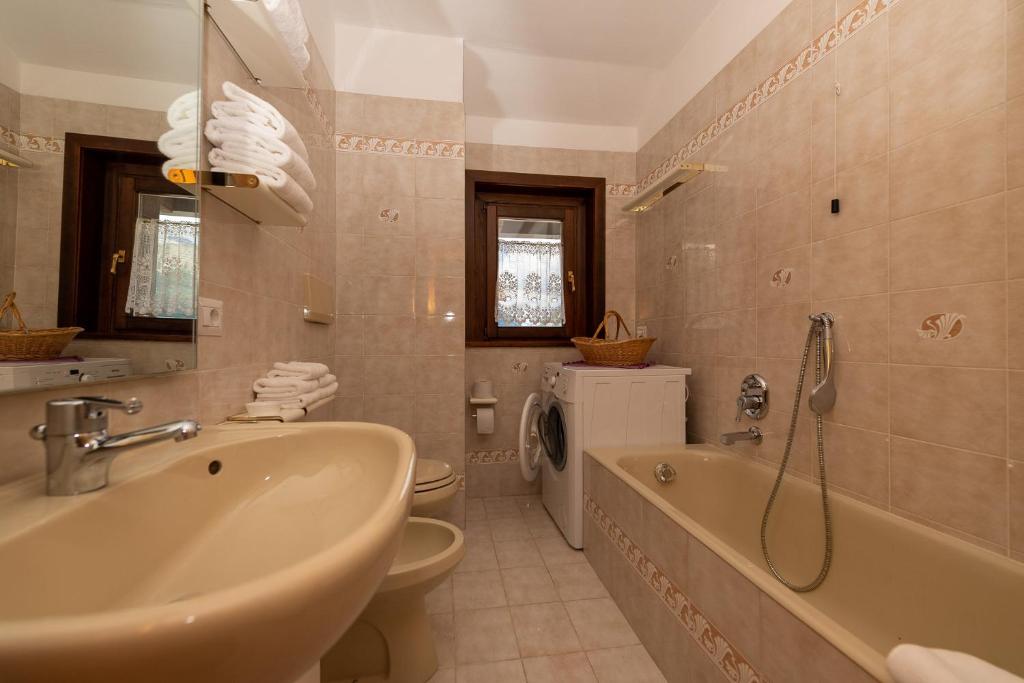 łazienka z umywalką, wanną i toaletą w obiekcie Chalet Rin Star w Livigno