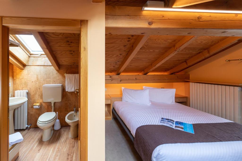 dwa zdjęcia sypialni z łóżkiem i łazienką w obiekcie Chalet Rin Star w Livigno