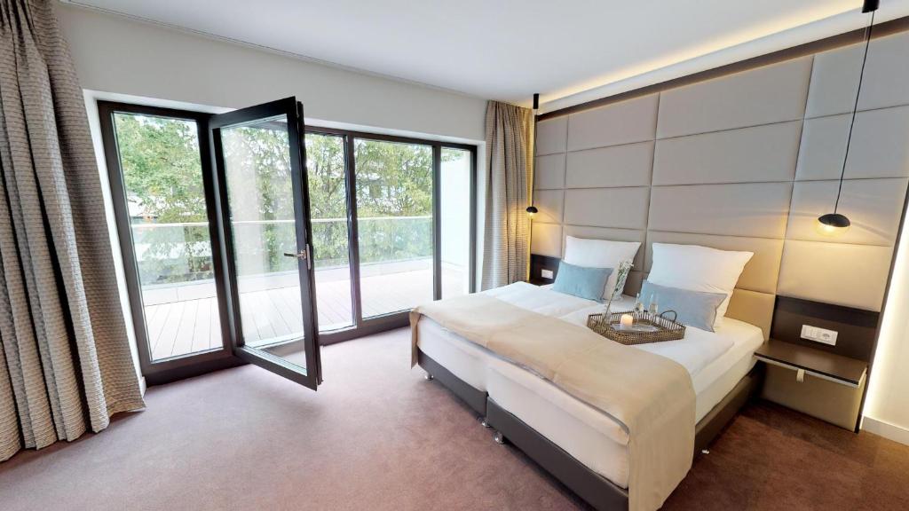 ein Schlafzimmer mit einem Bett und einem großen Fenster in der Unterkunft White Pearl Apartment 3.08 in Timmendorfer Strand