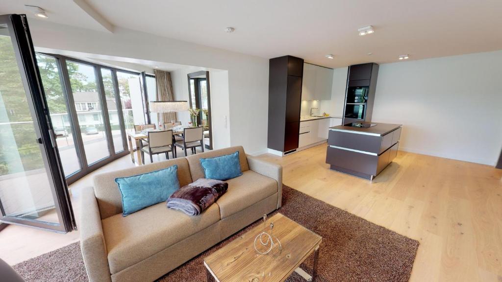 uma sala de estar com um sofá e uma mesa em White Pearl Apartment 2.16 em Timmendorfer Strand
