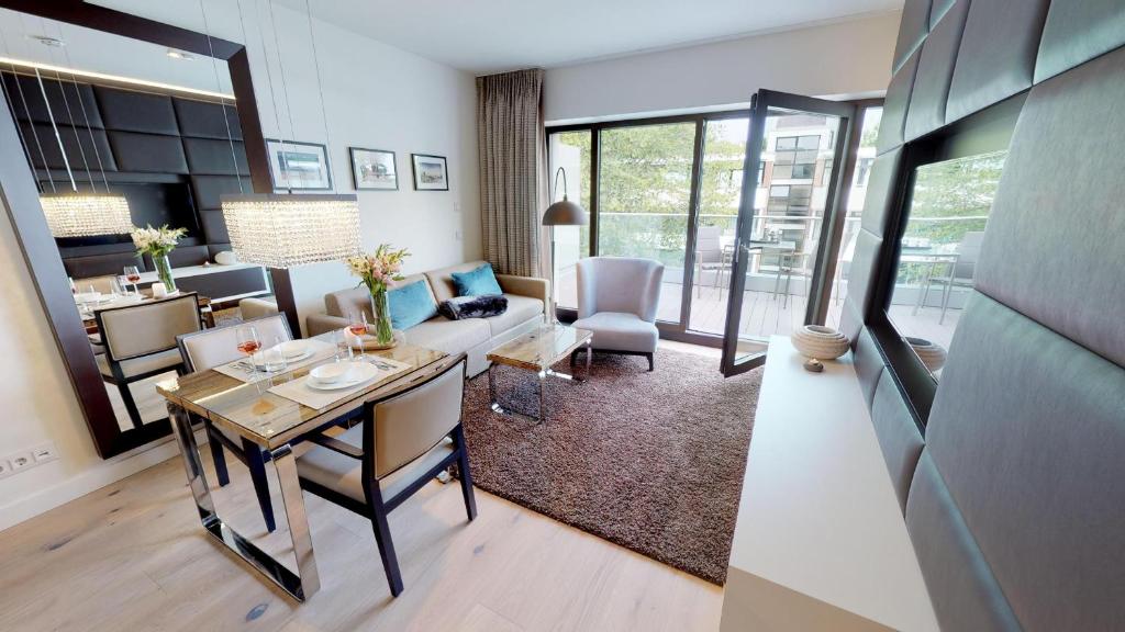 a living room with a table and a dining room at White Pearl Apartment 3.10 in Timmendorfer Strand