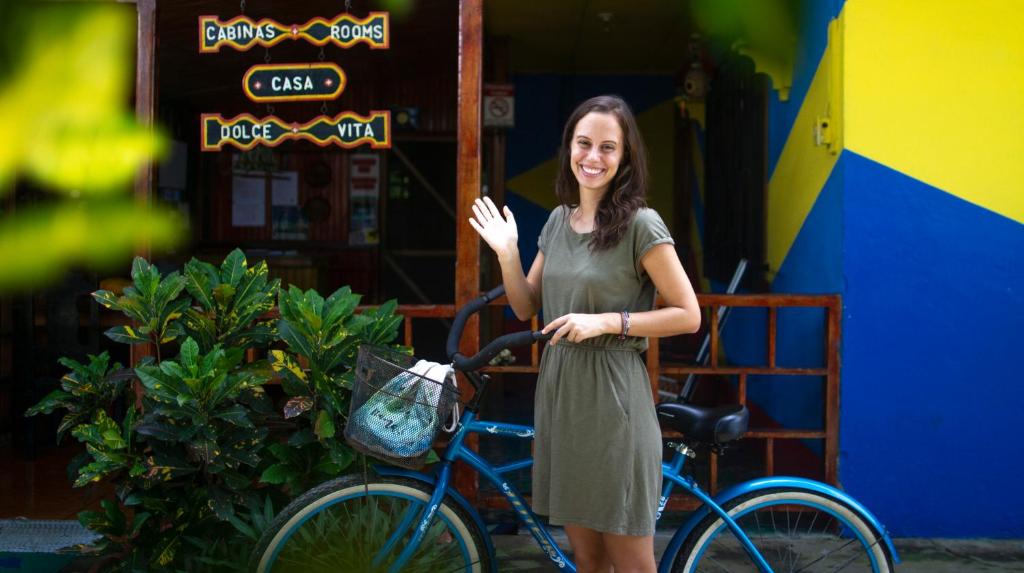 uma mulher está ao lado de uma bicicleta em Cabinas Casa Dolce Vita em Puerto Viejo