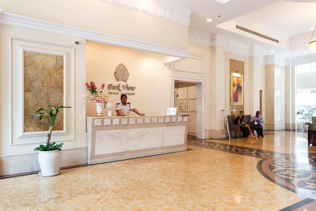 a woman standing behind a counter in a lobby at Parkview Suites KLCC by Airhost in Kuala Lumpur