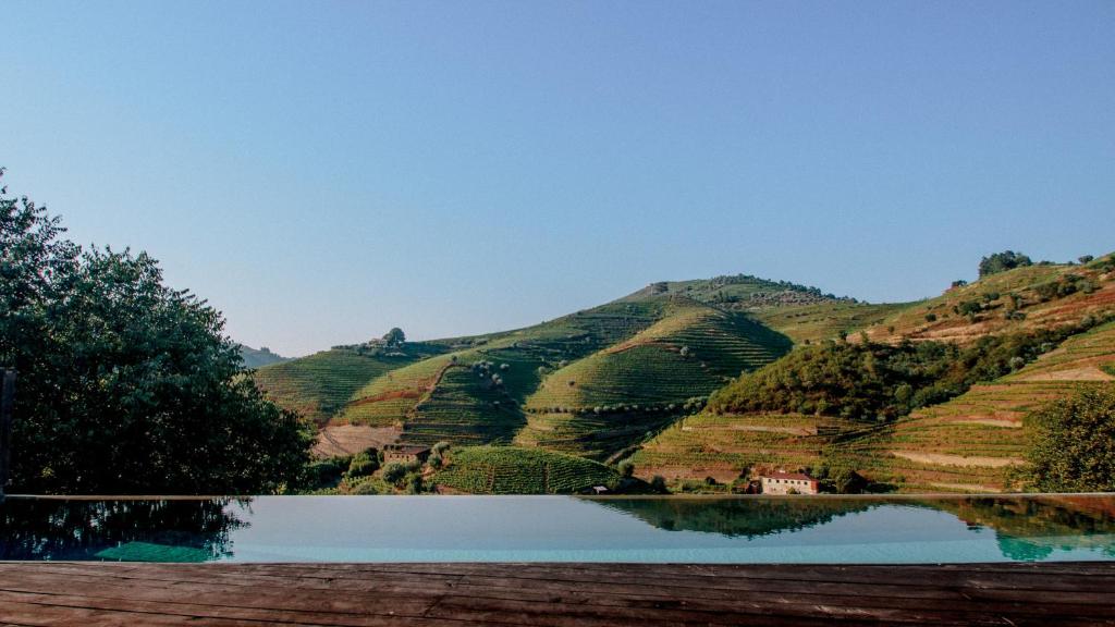 a view of a mountain with a reflection in a lake at Quinta do Vale da Ermida in Ermida