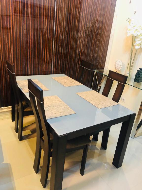 a table with chairs and a blue table and a table and chairs at Luzville Residences - C5 in Naic