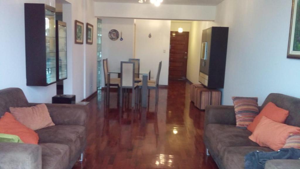sala de estar con 2 sofás y comedor en Residencial Pershing, en Lima