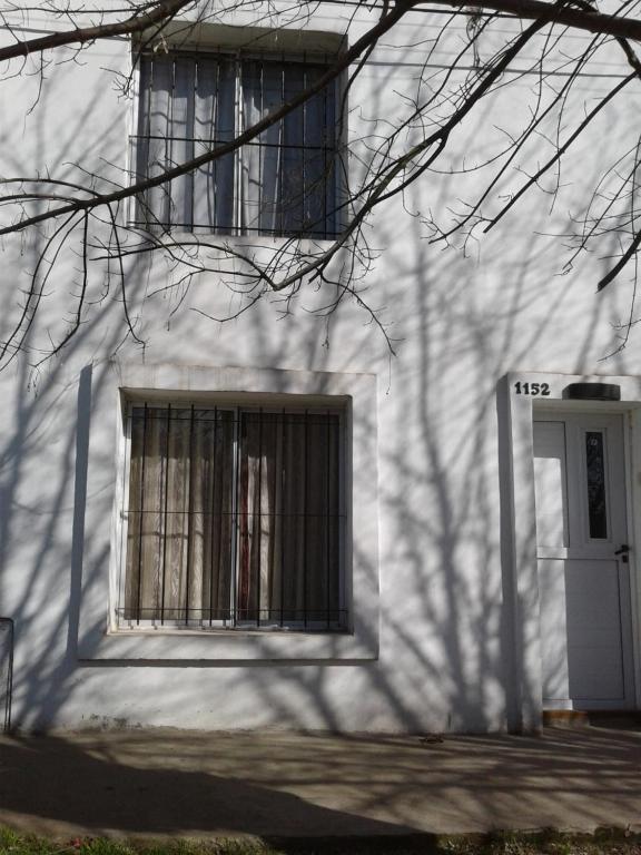 ein weißes Gebäude mit einem Fenster und einer Tür in der Unterkunft Juana 1152 in Balcarce