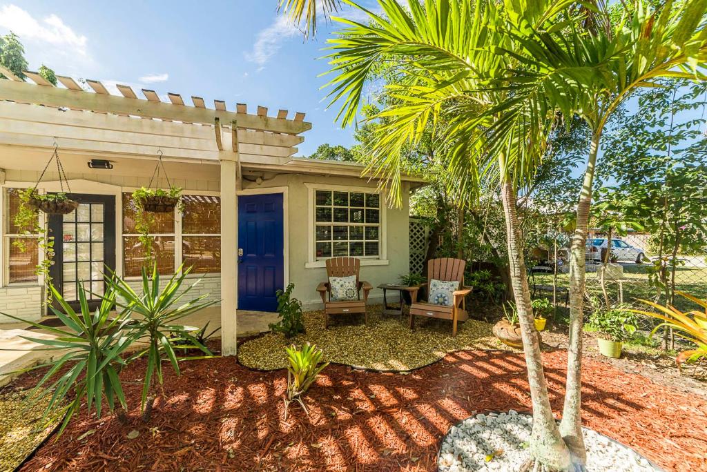 a house with a blue door and palm trees at The Blue Door Inn in Fort Lauderdale