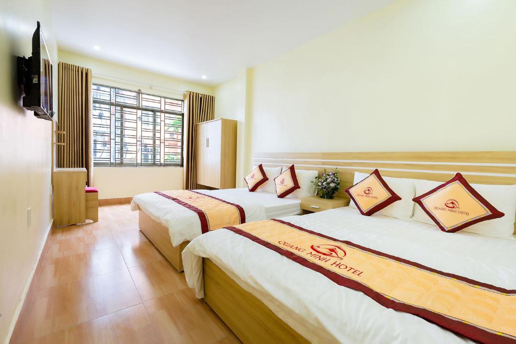 a hotel room with two beds and a television at Quang Minh Hotel in Cat Ba