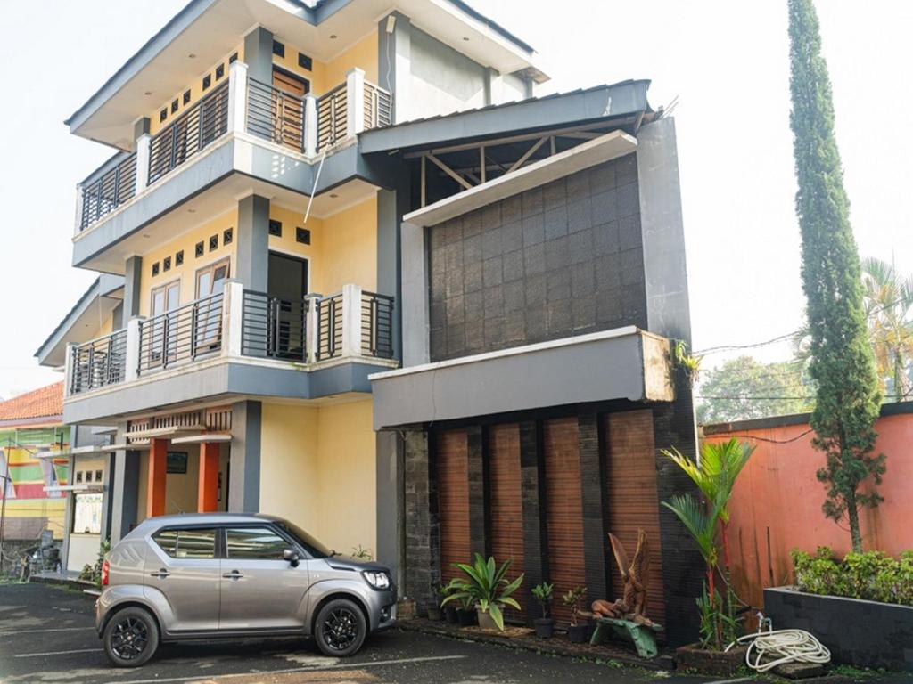 a car parked in front of a house at RedDoorz Plus @ Cibogo Puncak 3 in Bogor