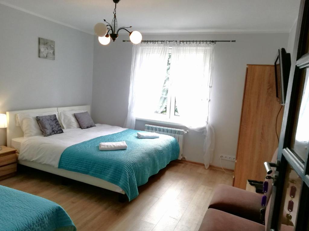 a bedroom with a bed and a window at Leśny Apartament in Szczytno
