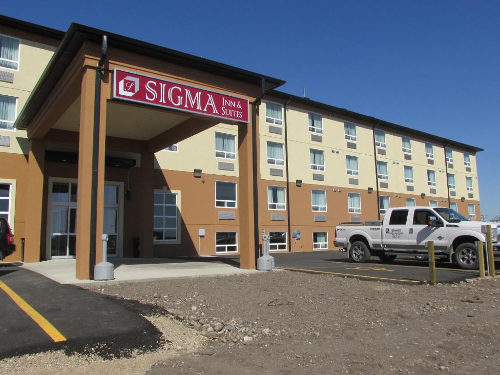 a white truck parked in front of a hotel at Sigma Inn & Suites in Melville