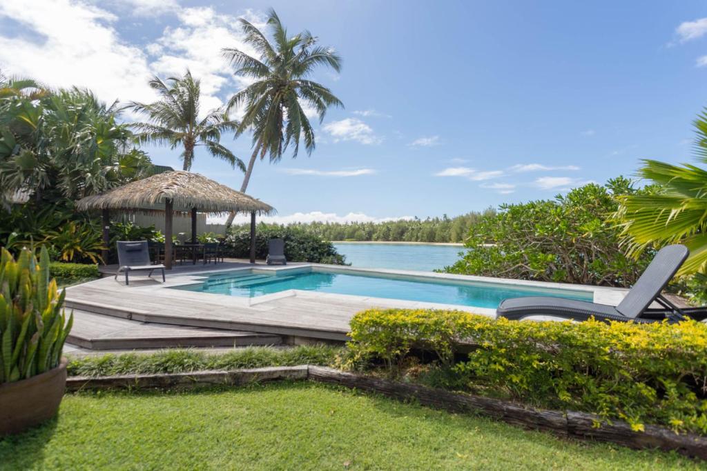 einen Pool mit Pavillon und Wasser in der Unterkunft Muri Beach Villa in Rarotonga