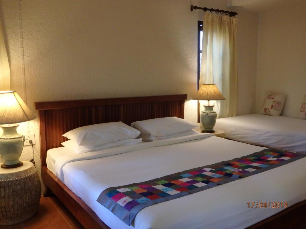 two beds in a room with two lamps and a bed sidx sidx sidx at Montien House - SHA Plus in Chaweng