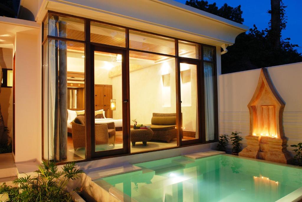 a swimming pool in front of a house at Montien House - SHA Plus in Chaweng