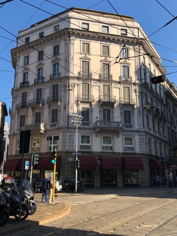 um grande edifício branco na esquina de uma rua em Hotel La Madonnina em Milão