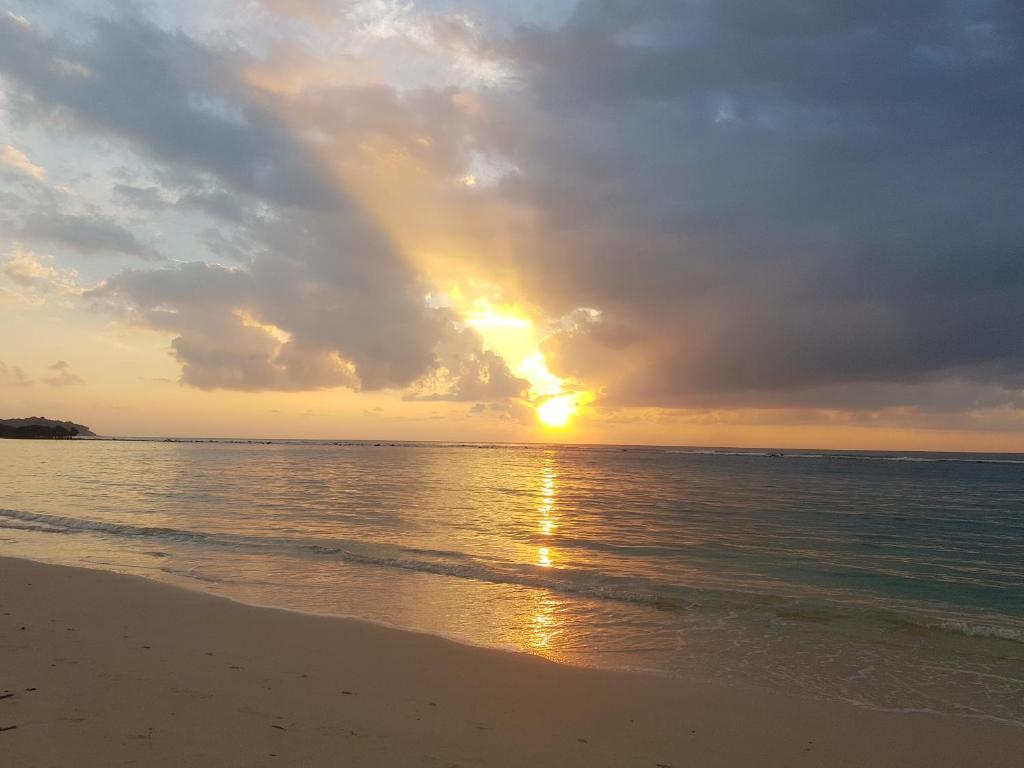 a sunset on the beach with a rainbow in the sky at Montien House - SHA Plus in Chaweng