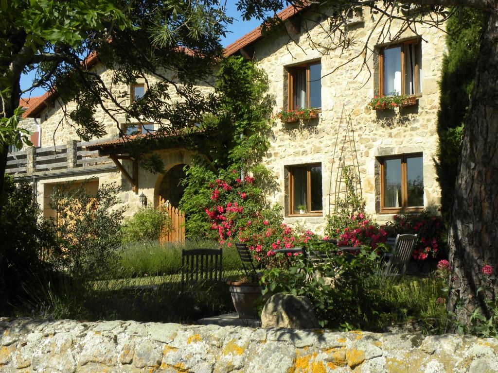 a stone house with a dog sitting in front of it at Atelier du Philosophe in Saint-Victor